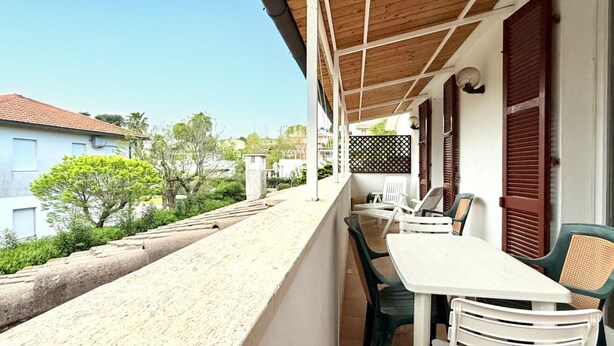 A balcony with a table and chairs, a wooden ceiling, and a view of the surrounding area. - M437 – Marcelli, two-room apartment with air conditioning (Marcelli)