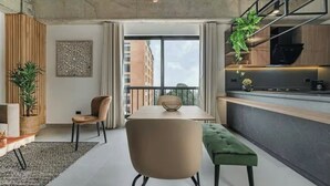 A modern kitchen with a dining area, a large window, and a staircase. - Poblado, 5 min to San Lucas Plaza, Free parking (Medellín)