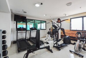 A gym with treadmills, elliptical machines, and free weights.