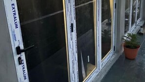 Une rangée de fenêtres dotées de vitres réfléchissantes et de cadres blancs, dont certaines portent des étiquettes.