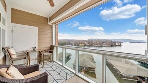 A balcony with wicker furniture, a glass railing, and a view of a lake and mountains. - #344 Pointe - 2 Bedroom Lakefront Condo at Mariners SML (Bedford County)
