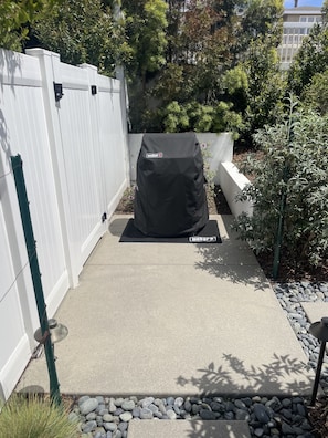 Enjoy al fresco dining at this outdoor grill area, complete with a covered grill and surrounding garden.