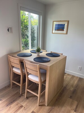 Enjoy meals in this cozy dining area with a table for four, comfortable chairs, and a beautiful view.