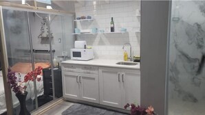 Una cucina moderna con mobili bianchi, un forno a microonde e un lavello.