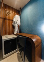 Un baño pequeño y moderno con tocador de madera, toallero y espejo.
