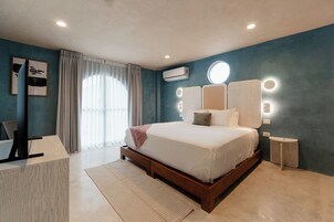 Un dormitorio moderno con una cama grande, un escritorio y un tocador con iluminación.
