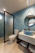 A bathroom with a toilet, sink, and mirror.
