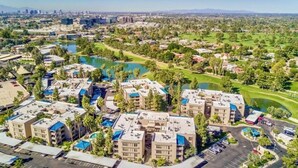 A residential area with apartment buildings, a golf course, and a city skyline in the background.