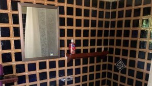 Une salle de bain avec un lavabo blanc, des toilettes et un miroir au-dessus du lavabo.