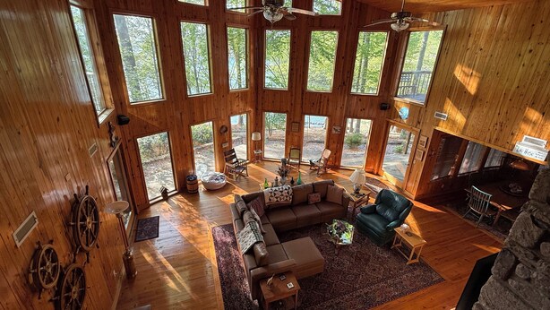A spacious cabin with large windows, a fireplace, and a cozy seating area.