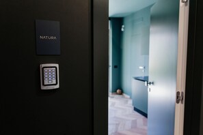 A door with a 'NATURA' sign and a 'RETEKESS' keypad lock.