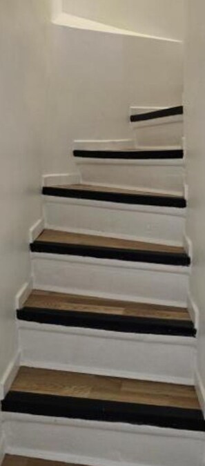 A staircase with white walls and wooden steps. - The enchanted alcove (Rouen)