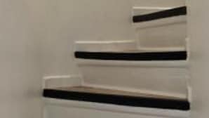 A staircase with white walls and wooden steps.