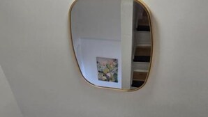 A modern interior with a ceiling light fixture and a wall-mounted mirror.