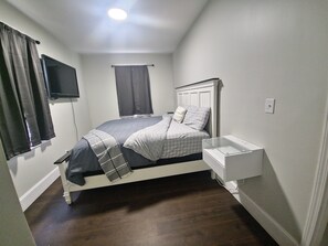 Cozy retreat with a single bed and mounted TV.