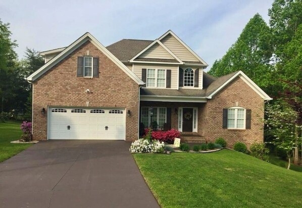 A two-story house with a brick facade, a front garage, and a well-maintained lawn. - Spacious guest apartment to enjoy. Only 12 Minutes from Liberty University. (Forest)
