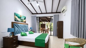 A modern bedroom with a bed, nightstands, a chair, and a view to an outdoor area.