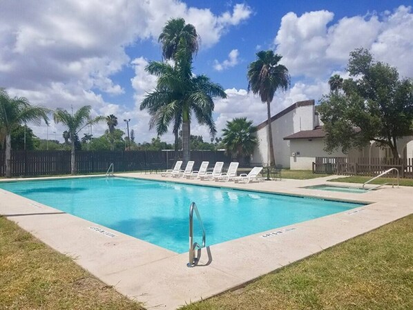 Relax by the rectangular pool surrounded by lounge chairs and lush greenery.