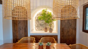 A dining area with a wooden table, wicker chairs, and two potted plants on a tray. - Cortijo Rural Fandango 3 - Pool and Mountain (Almuñecar)