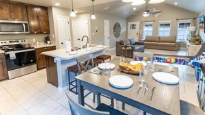 A spacious kitchen with a central island, modern appliances, and a dining area.