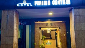L'ingresso dell'Hotel Pereira Central, con una segnaletica chiara, una reception e piante in vaso.