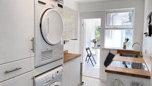 Una cocina moderna con electrodomésticos integrados, un comedor con luz natural y vistas al exterior.