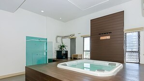 A modern bathroom with a large bathtub, a wooden vanity, and a glass shower enclosure. - 1 quarto, cheio de estilo, condo club Sky com vaga (Curitiba)