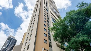A high-rise building with multiple floors and a modern architectural design. - 1 quarto, cheio de estilo, condo club Sky com vaga (Curitiba)