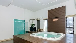 A modern bathroom with a wooden vanity, a glass bathtub, and a potted plant. - Oásis Urbano com Vistas Deslumbrantes no Sky CWB (Curitiba)