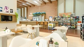 A modern hotel lobby with a reception desk, seating area, and a pharmacy. - 2 Quartos com Garagem vista incrível no Batel 27a (Curitiba)