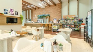 Un café moderno con barra, asientos y diversas opciones de comida y bebida.