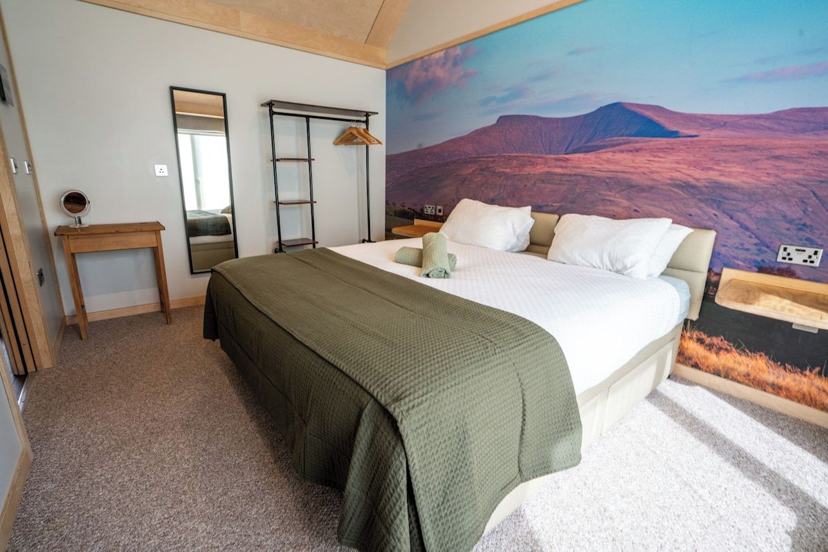 Une chambre à coucher avec un grand lit, une table de chevet, un miroir et une armoire.