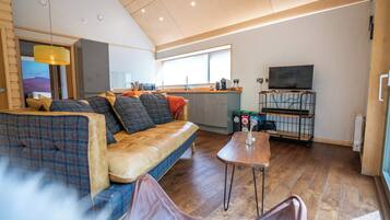 A modern living room with a sofa, a coffee table, and a television.