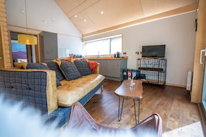 A modern living room with a sofa, a coffee table, and a television.