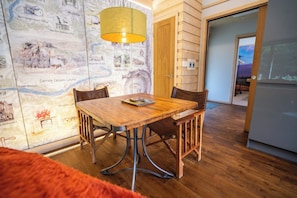 Ein Essbereich mit Holztisch und Stühlen, einer Wand mit einer Karte und einer Tür zu einem anderen Raum.