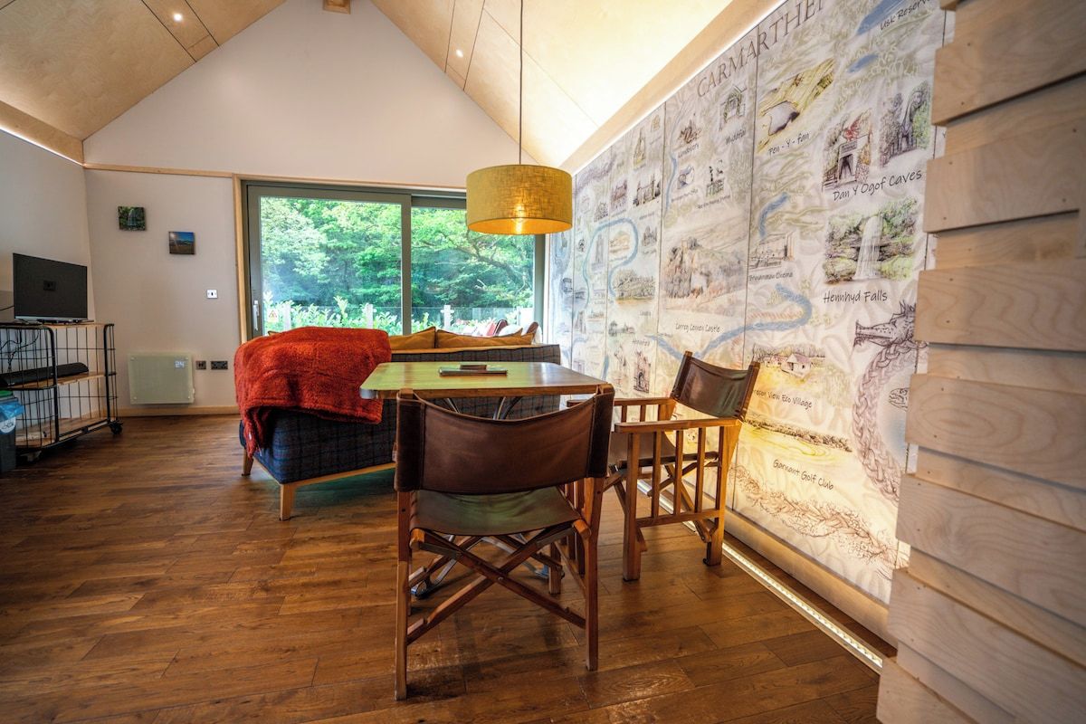 A cozy room with a dining table, chairs, a television, and a large window.