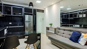 A modern kitchen with a built-in refrigerator and a dining area with two chairs.