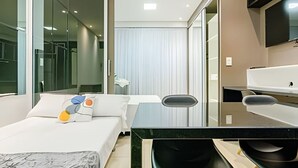 A modern hotel room with a bed, a desk, and a TV.
