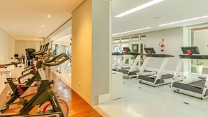 A modern gym with stationary bikes, treadmills, and exercise equipment.