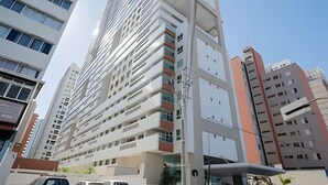 A modern high-rise building with multiple balconies and a glass facade. - Apartamento com Vista do 22º Andar, Piscina Aquecida e Garagem | Batel, Curitiba (Curitiba)
