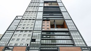 A high-rise building with multiple floors, large windows, and a modern architectural design.