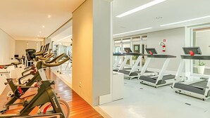 A modern gym with multiple exercise machines and treadmills.