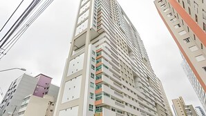 A high-rise building with multiple balconies and a modern architectural design.