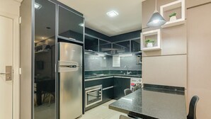A modern kitchen with a refrigerator, oven, and dishwasher. - 1 quarto elegante e sofisticado lifespace Curitiba (Curitiba)