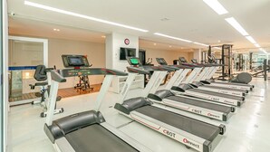 A gym with multiple treadmills, weight machines, and a digital display. - 1 quarto elegante e sofisticado lifespace Curitiba (Curitiba)