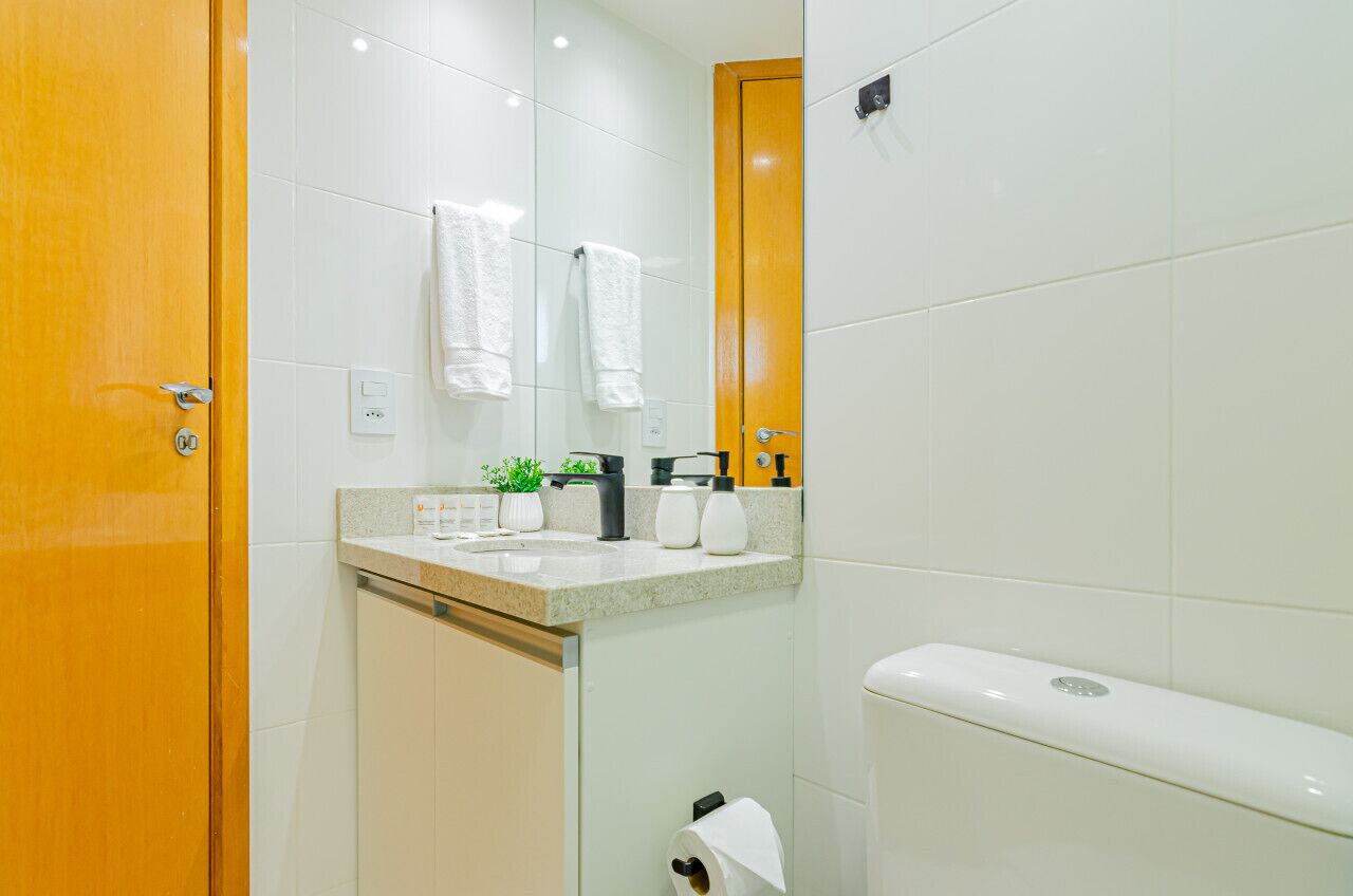 Une salle de bain avec un lavabo, un miroir et des toilettes.