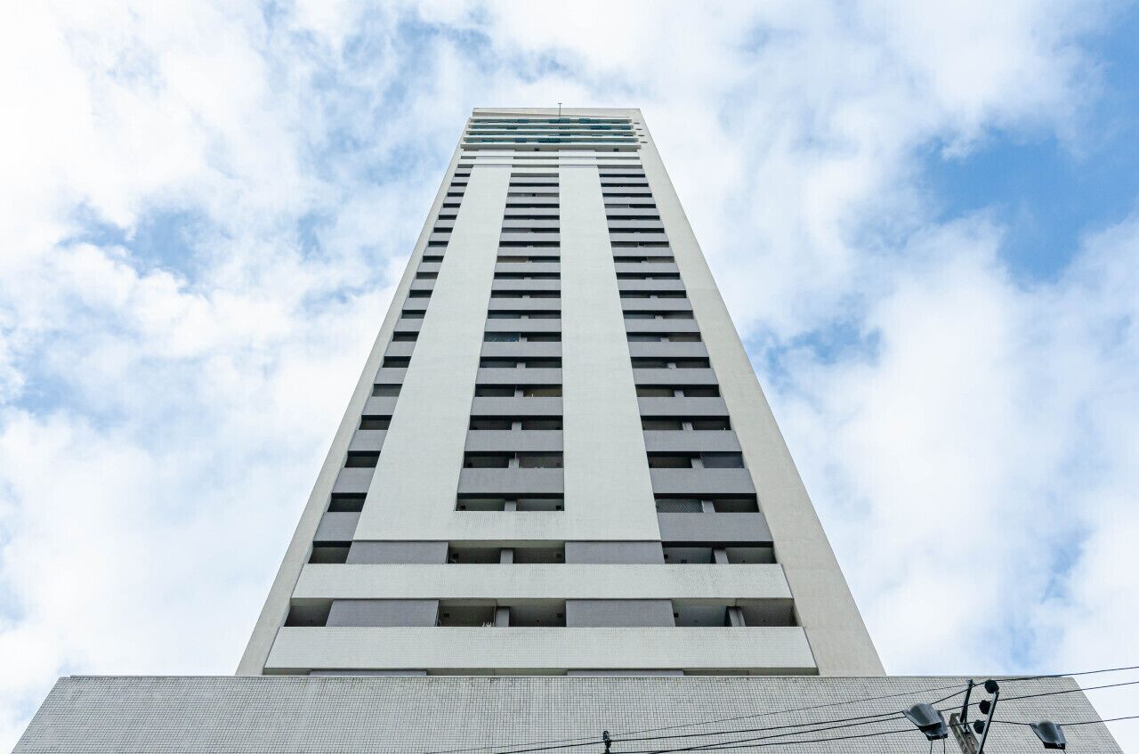 A tall, modern building with a grid of windows and a flat roof.