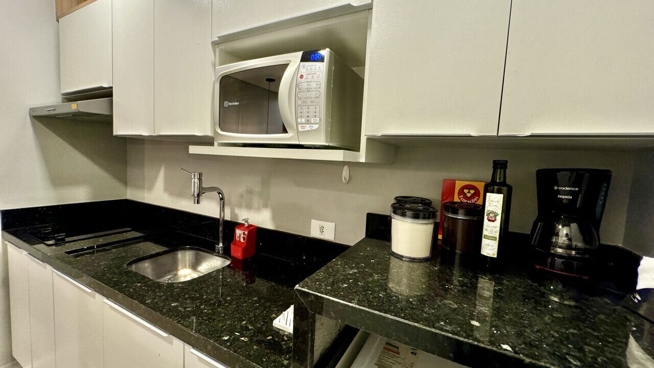 A kitchen with a microwave, coffee maker, and various kitchen items on the counter.