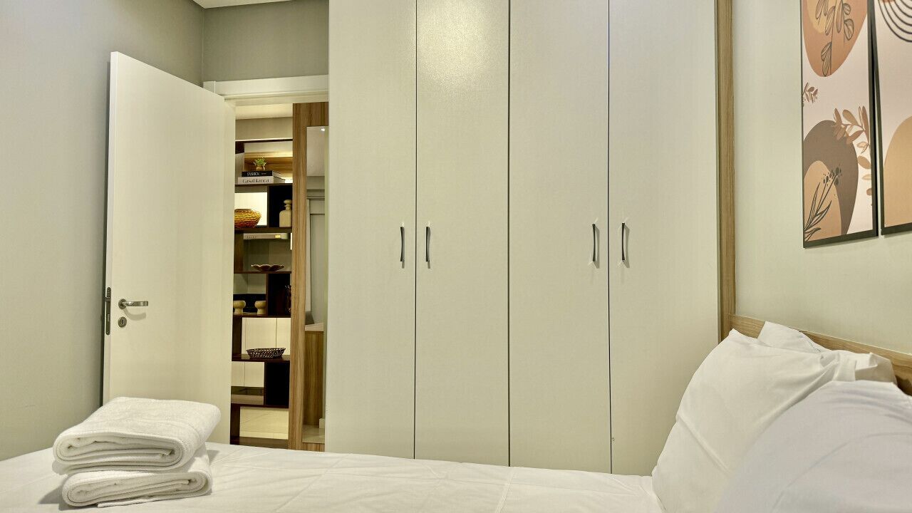 A hotel room with a bed, a wardrobe, and a walk-in closet.