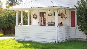 A white house with a covered porch, a welcome sign, and bird feeders. - 30-Day Min, Walking Distance to Downtown & Lake + Pet Friendly! (Whitefish)